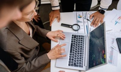 echipa la computer pentru articol seo vs geo. o lupa pe masa